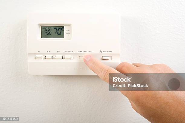 Closeup Of Hand Operating The Home Heating System Controls Stock Photo - Download Image Now