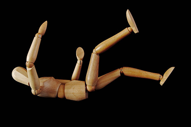 Artist's figure falling A wooden artist's figure falling backwards, insulated on black background person falling backwards stock pictures, royalty-free photos & images