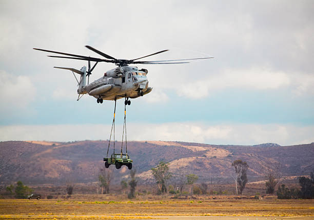 A CH53e Super Stallion delivers a howitzer during a military support demonstration.