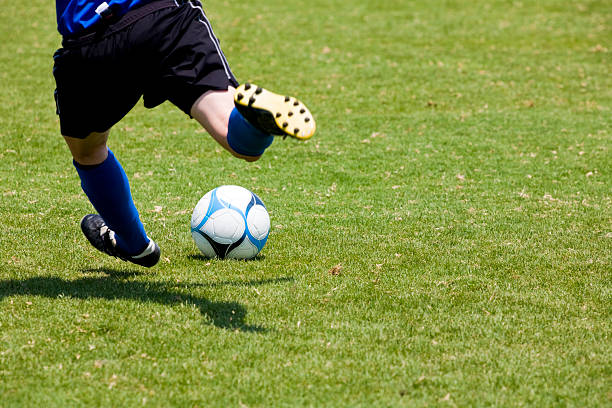 Close-up of soccer player's feet throwing a free kick stock photo