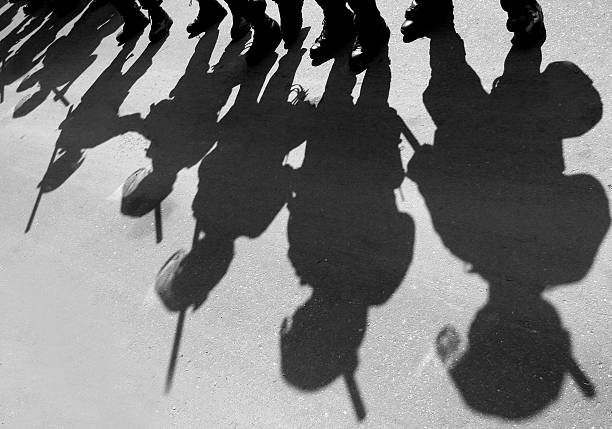 Riot Police Shadows of riot police on a city street. big brother orwellian concept photos stock pictures, royalty-free photos & images