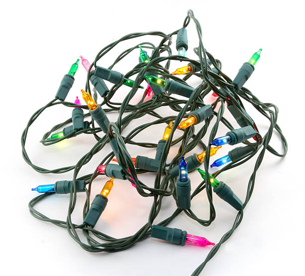 Tangled Christmas Lights A pile of lit christmas lights all tangled up. string light stock pictures, royalty-free photos & images