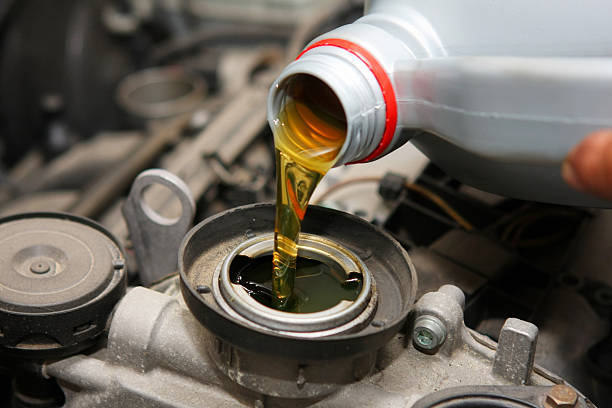 In auto repair shop...Car mechanic is changing engine oil Motor oil change lubrication stock pictures, royalty-free photos & images