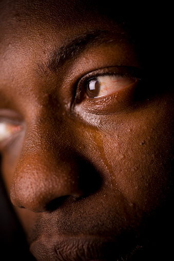 A close up of a black man crying.