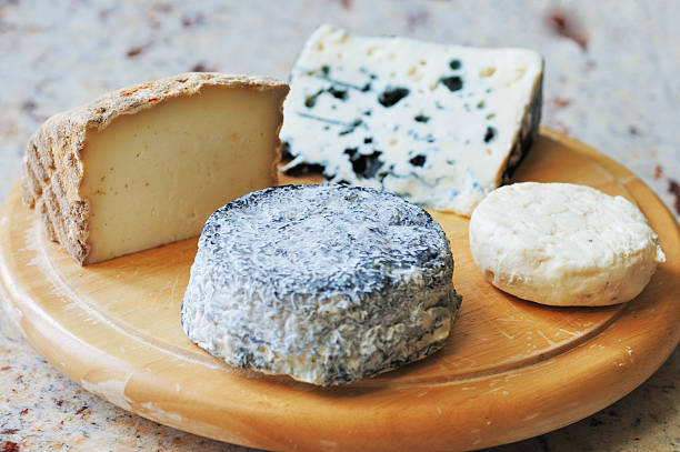 Selected French cheeses in perfect condition. Left, Pyrenean goat cheese with brown crust, back, Roquefort (blue, sheep), right, Picodon goat cheese (small round) and front Selles-sur-Cher blue goat cheese