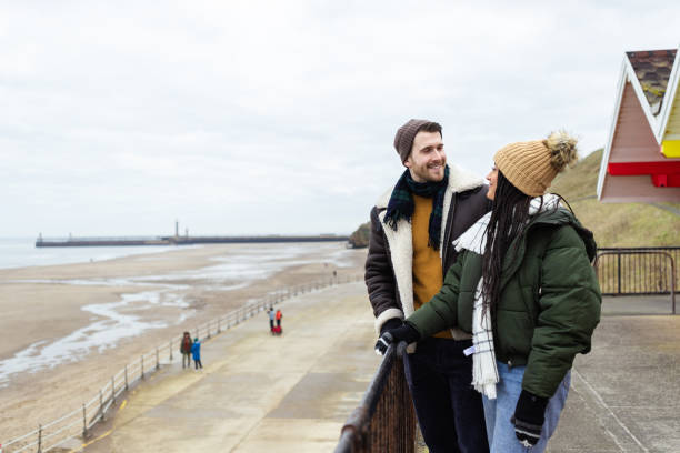 istock Couple Embracing the Cold Beach Scenery 1706188788
