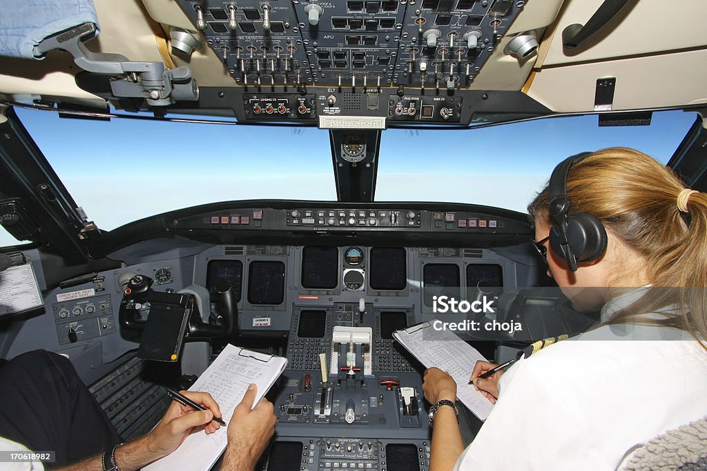 Volando joven piloto, checkind data.Cockpit de un avión - Foto de stock de Avión libre de derechos