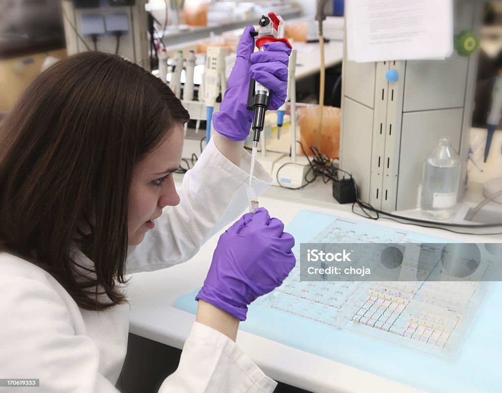 Bellissimo tecnico al lavoro in una banca del sangue di laboratorio. - Foto stock royalty-free di Analizzare