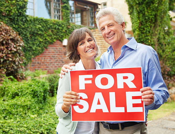 istock Mature couple holding for sale billboard 170619489