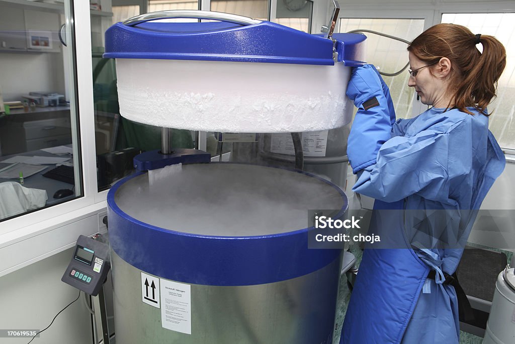 Pojemnik z płynem nitrogen.doctor w kombinezonie ochronnym w pracy - Zbiór zdjęć royalty-free (Badania)