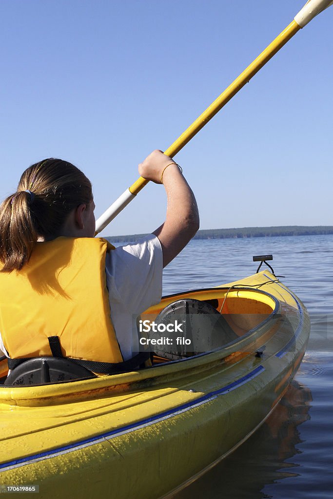Young Kayaker A young girl in a yellow kayak paddling. Kayak Stock Photo
