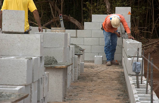 Masonry Construction A CMU Wall being erected. bricklayer stock pictures, royalty-free photos & images