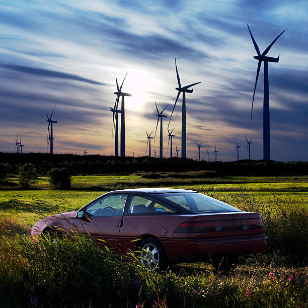 Windmills and car against sunset stock photo