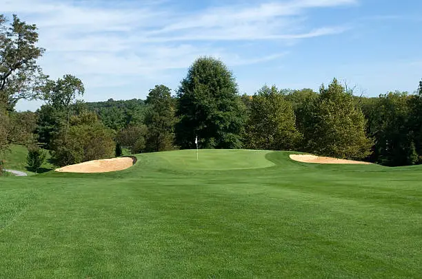 A view of the green from the fairway on a beautiful day.