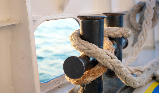 zbliżenie liny żeglarskiej z węzłem żeglarskim na bitach do łodzi i cumowania. - moored nautical vessel tied knot sailboat zdjęcia i obrazy z banku zdjęć
