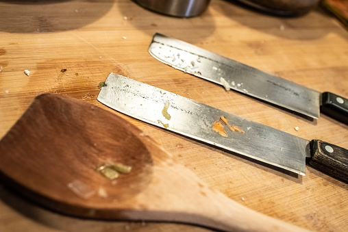 Steel kitchen knives and wooden spoon.