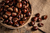 Chestnuts in a wooden plate on a burlap sack