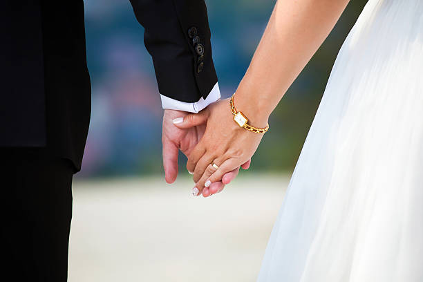 istock A young, married couple linking their hands 170623425