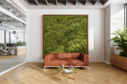 Waiting Area In Eco-Friendly Modern Open Plan Office With Sofa, Coffee Table And Vertical Garden