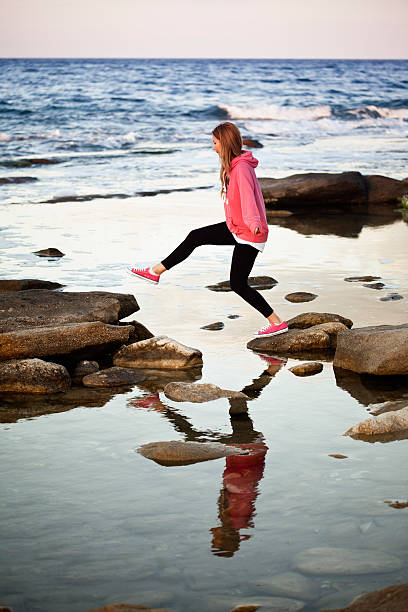 istock Young Woman Balancing on Rocks in Lake 170625302