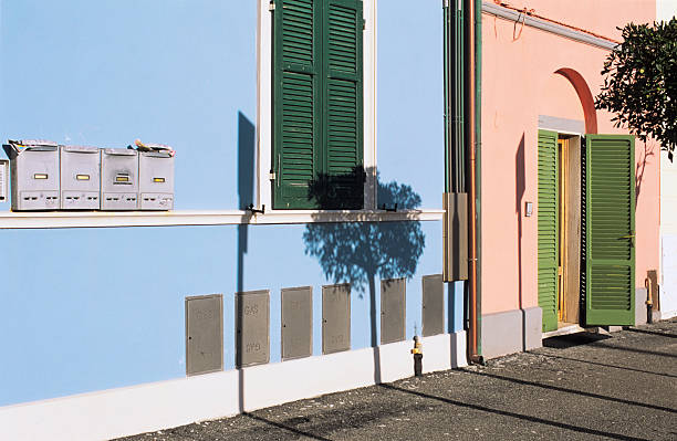Sunny scene photographed in a residential area of Marina di Pisa, Tuscany, Italy. Windows and mailboxes and gas boxes are visible.
