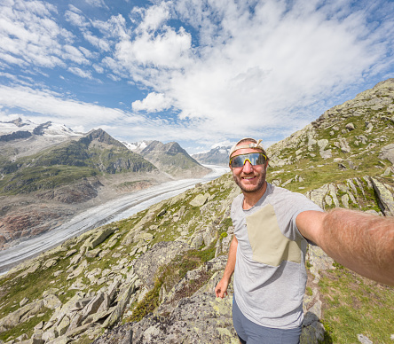 Hiker taking selfies with glacier view in Switzerland