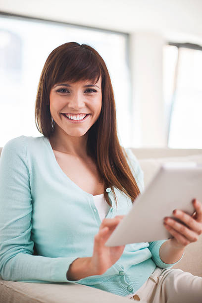 istock Woman at home holding her tablet computer. 170626981