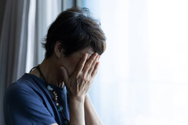 istock An old woman is crying, covering her face with her hands 1706275512