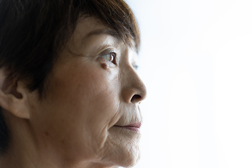 Close-up of an old woman's pensive eyes staring into the distance.
Mental pain, suffering, grief.
Loneliness, alienation.
Instability. Depression. Trauma.
She is a Japanese woman in her seventies.
