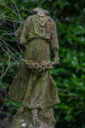 Headless Angel Statue in a weathered and dilapidated Graveyard
