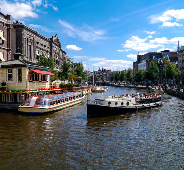Boat tour in Amsterdam, Netherlands - Aug 14, 2023: tourists are sightseeing on a tour boat