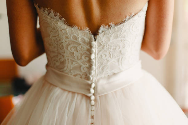 istock Bride getting ready, they help her by buttoning the buttons on the back of her dress. 1706312627