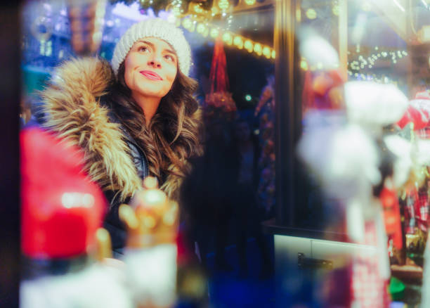 A woman enjoying a visit to winter market stalls in December in Edinburgh, Scotland.