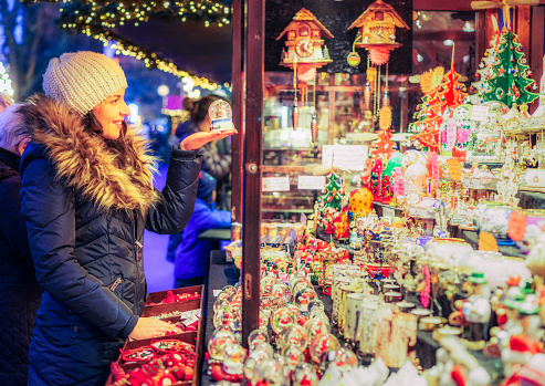 A woman looking for a present at a outdoor Christmas market stall in Edinburgh, Scotland.