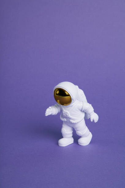 istock an astronaut figurine in a spacesuit exploring a plain purple background 1706322500