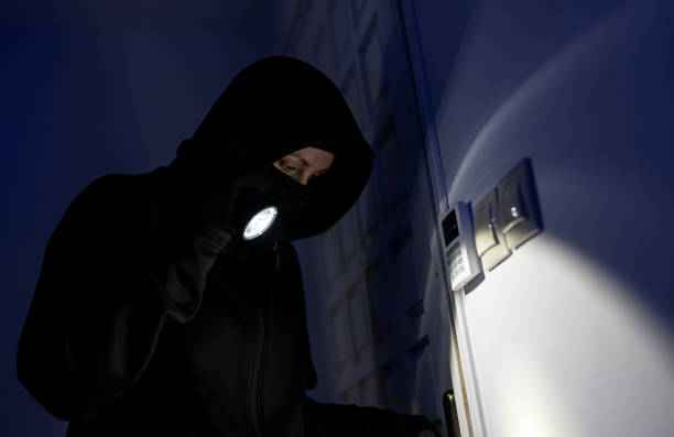 istock Female thief breaks into the apartment through the front door. 1706325260