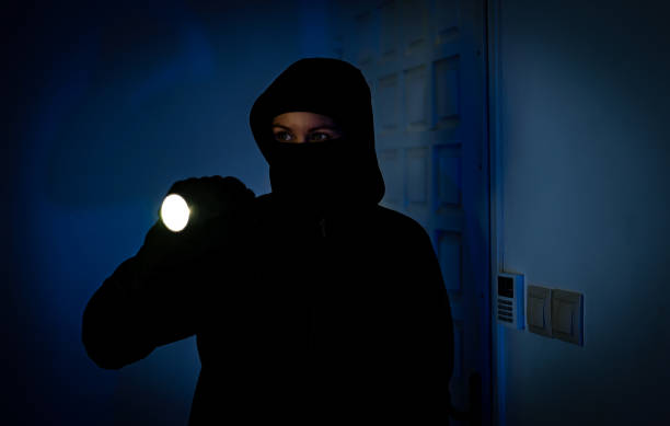 istock Female thief breaks into the apartment through the front door. 1706325265