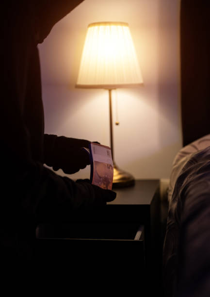 istock Female thief steals money from the bedside table. 1706325689