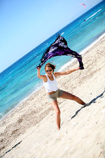 Felice giovane donna saltando sulla spiaggia - foto stock