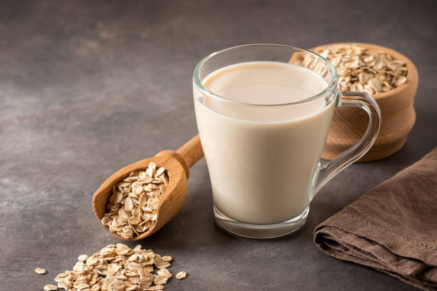 istock Oat milk close-up in a glass on a brown rustic background. Side view, selective focus. Copy space. 1706338463