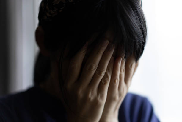 Close-up of the face of a blonde woman. Her hair is blowing in the wind. She looks down. Her expression betrays sadness and farewell.