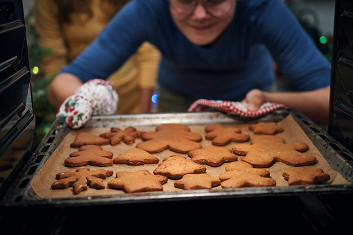 Teenage Girls Baking Christmas Cookies in the Oven