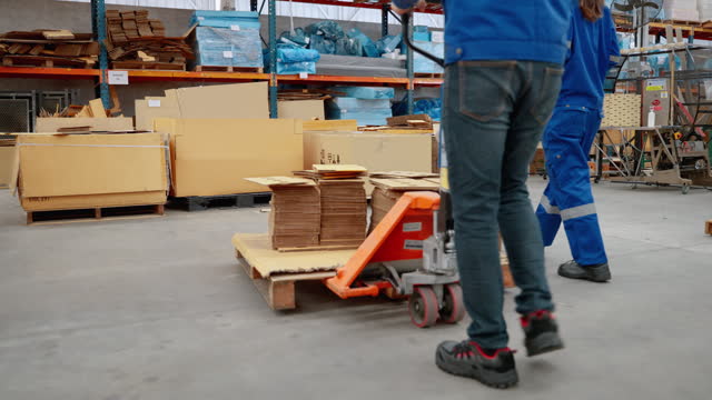 worker uses a cart to move goods inside a paper factory.