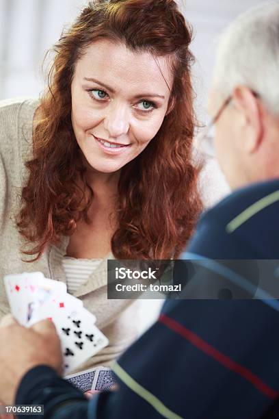 Mulher De Idade Mediana Cartas De Jogar Com O Pai - Fotografias de stock e mais imagens de 40-44 anos - 40-44 anos, Adulto, Adulto de idade mediana