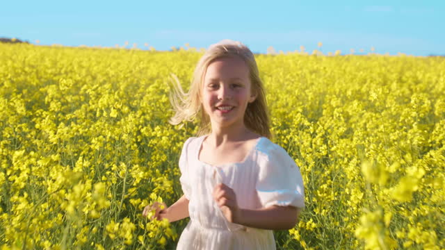 Running, child and flowers in nature, field or freedom in countryside, farm or happy in landscape. Kid, run and smile in summer or spring portrait in environment bloom with green and yellow plants