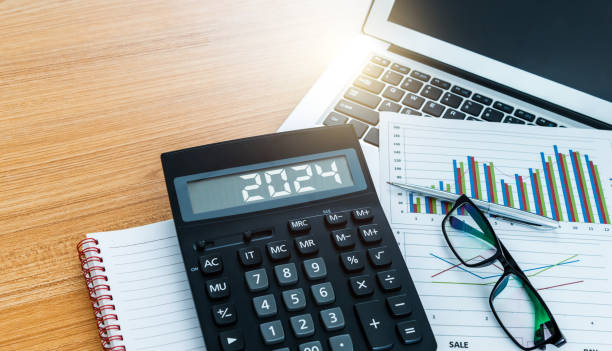 New year number 2024 on the calculator screen,  at financial analysis desk stock photo
