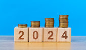 New year 2024 wooden numbers with coins on the table