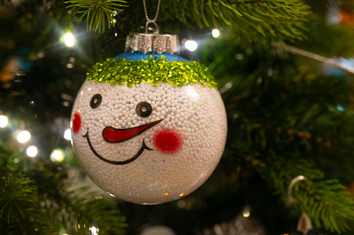 Close up of a snowman Christmas decoration hanging on the Christmas tree