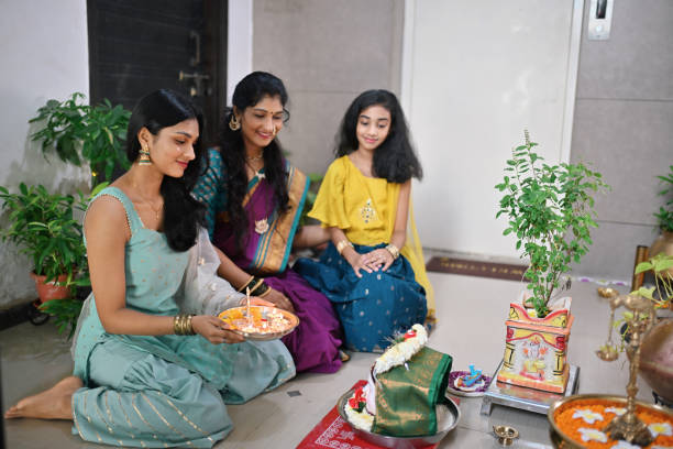 istock Indian women with her daughters worshipping Gauri idol 1706417110