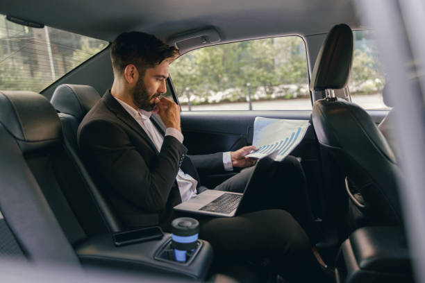 istock Confidence businessman sitting on car backseat and working with documents while going to office 1706430210